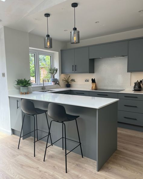 This sleek modern grey kitchen is such a calm and relaxing space, the stools at the peninsula providing the perfect spot for that first blissful morning coffee ☕️ #honestlydesignedwithlifeinmind #interiorskitchenslife #sleekkitchen #kitchenpeninsula #modernkitchendesign #contemporarykitchen #simplekitchendesign #calmkitchen #neutralkitchendecor #modernkitchendecor #contemporarylighting #moderninteriorstyle #kitcheninteriordesign #independentdesigner #hampshirekitchens #berkshirekitchens #qua... Kitchen Design Gray, Peninsula Kitchen Design, Gray Flooring, Peninsula Kitchen, Modern Grey Kitchen, Kitchen Peninsula, Simple Kitchen Design, Relaxing Space, Sleek Kitchen