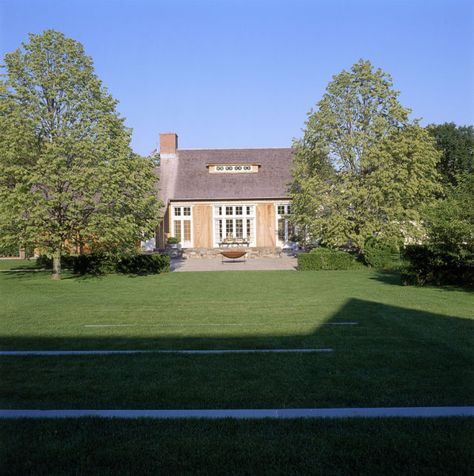 On a shady side street of East Hampton, New York, Ina Garten built her "barn," inspired by the simple country buildings of Belgium and designed by architect Frank Greenwald. Ina loves to entertain outdoors, and "all my guests love to sit on the stone sitting wall before dinner, having a glass of wine," she says. After dinner, everyone gathers around the big iron fire bowl to roast marshmallows and make s'mores.   - CountryLiving.com Ina Garden, Hampton Home, Beautiful Bathtubs, Barefoot Contessa, Hamptons Style, Fire Bowls, East Hampton, Celebrity Houses, Barn House