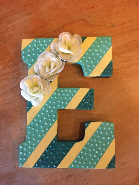 DIY wall art. Painted wooden letter with stripes. Glitter and flowers added for embellishment.   Wooden letter E (Hobby Lobby) Paint- Lemon ice and Aqua (Joann Fabrics brand), Laguna (Apple Barrel brand) Glitter- Stickles colors Aqua and Crystal Flowers (Hobby Lobby) Wooden Letter Painting Ideas, Wood Letter Painting Ideas, Letter Decoration Ideas, Wood Letter Crafts, Wooden Letter Ideas, Wooden Letter Crafts, Painted Wood Letters, Wooden Letters Decorated, Painting Wooden Letters