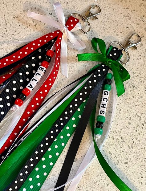 Each item includes 15-20 Ribbons Ribbons hang about 6-7 inches on both sides from a sturdy 1 inch Silver Swivel Clasp keychain.  Made in colors requested in a variety of ribbons that I have available. They are each topped with a bow in a matching color..  Ribbon pattern and designing may differ in EACH bag tag  Message me to order team bag tags. Bulk discounts are available. When Ordering Please List---- Name or Team (CHECK SPELLING), Colors (up to 3 colors) Accent Colors may be added as needed. Personalized Ribbons will have the name in beads along with coordinating colored beads. Gift Bags For Cheerleaders, Cheer Favors Cheerleading Cute Ideas, End Of Season Team Gifts, Diy Ribbon Tassel Keychain, How To Make Ribbon Keychains, Ribbon Bag Tags Diy, Cheerleading Good Luck Gifts, Diy Bag Tags Sports, Ribbon Zipper Pull Diy