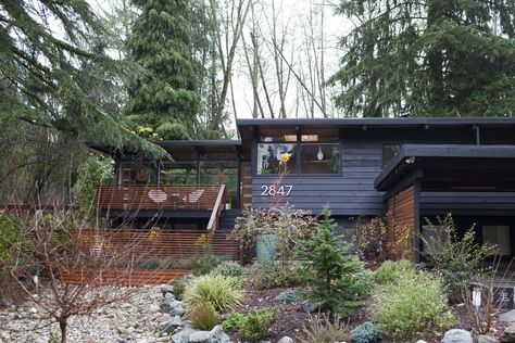 The MCM look never goes out of style.  Peak inside to see why this aesthetic withstands the test of time Mid Century Cottage, Home In The Woods, Mid Century Modern Exterior, Apartment Painting, Mid Century Exterior, Seattle Homes, Dark House, Survival Shelter, House Deck