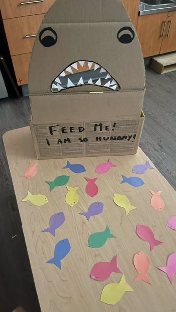 Brooke and Cat on Instagram: "Feed the Shark !🦈 . . . This week the toddler have had a great interest in water animals. So I thought this easy fun activity would be the right fit. All handmade. . . All you need is a cardboard box, some construction paper and your creativity. . . . Don’t forget to save and follow for more great ideas. . . . #popular #instagram #trending #follow #love #viral #like #instagood #explorepage #photography #explore #likeforlikes #followforfollowback #music #fashio Feed The Shark Activity, Water Animal Activities For Preschool, Aquatic Animals Preschool Activities, Sea Animals Activities For Toddlers, Baby Shark Activities For Toddlers, Shark In The Park Activities Eyfs, Shark Activities For Preschool, Shark Activities For Kids, Sea Animals Preschool