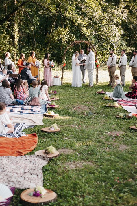 Outdoor Wedding with blanket and wooden chair seating for guests. Wooden slabs for bridal party entrance. 
Wedding arch made out of sticks. Colorful summer wedding. Bridesmaids alternatives, bouquet Bridesmaids holding wicker fan. Groomsmen in suspenders. Rainbow colors for wedding. Wedding Seat Ideas Outdoor, Picnic Style Wedding Ceremony, Picnic Blanket Wedding Seating, Picnic Ceremony Wedding, Picnic Blanket Wedding Ceremony, Blanket Seating Wedding, Outdoor Picnic Wedding Ideas, Wedding Picnic Blankets, Floor Seating Wedding Ceremony