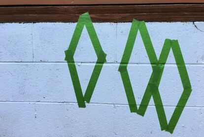 A cinder block wall does not have to be plain or an eyesore. Just grab some paint and a stencil and turn it into a feature! Our deck was built on a cinder block foundation, which is right by the swimming pool. I was tired of it looking unfinished, so I decided to paint it white, then added a pop of color with a fun design. See how I transformed this wall in one afternoon! I had painted the wall several years ago, but it was in need of a fresh coat of paint. After pressure washing the… Backyard Wall Murals Cinder Blocks, Mural On Cinder Block Wall, Paint Cinder Block Wall, Cinder Block Foundation, Backyard Wall, Block Foundation, Accent Wall Entryway, Hallway Gallery Wall, Accent Wall Stencil