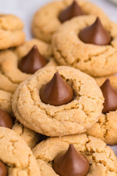 Peanut Butter Blossoms are timeless, classic cookies perfect for the holiday season. A peanut butter cookie topped with a chocolate kiss. Peanut Butter Kisses Cookies, Christmas Treat Tray, Peanut Butter Cookies With Kisses, Cookies Cream Cheese Frosting, Cookies With Kisses, X Mas Cookies, Peanut Butter Kisses, Old Fashioned Peanut Butter Cookies, Easy Chocolate Pie Recipe