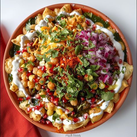 As a famous Indian street food snack, papdi chaat is renowned for its irresistible blend of fried dough wafers, tangy chutneys, creamy yogurt, and an assortment of savory toppings. This delicious chaat is full of different tastes and textures, which is why food lovers all over India love it. It doesn't matter if you eat papdi chaat as a quick snack on the go or as part of a holiday feast; it always tastes great and looks amazing. Papdi chaat is a true celebration of India's rich culinary history and street food culture. Its bright colors and strong tastes make it stand out. Papdi Chaat Recipe, How To Make Cauliflower, Creamy Yogurt, Tamarind Chutney, India Love, Crispy Chickpeas, Chaat Recipe, Green Chutney, Food Snack