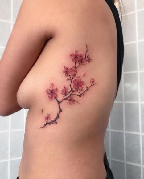 70 Cherry Blossom Tattoo Designs And Ideas To Try In 2023 Back Tattoo Women Spine Cherry Blossoms, Cherry Blossom Side Tattoos Women, Cherry Blossom Tattoo Rib Cage, Cherry Blossom Tattoo On Black Women, Cherry Blossom Tattoo Aesthetic, Red Blossom Tattoo, Mugunghwa Flower Tattoo, Spine Tattoos Cherry Blossoms, Cherry Blossom Tattoo Side Ribs