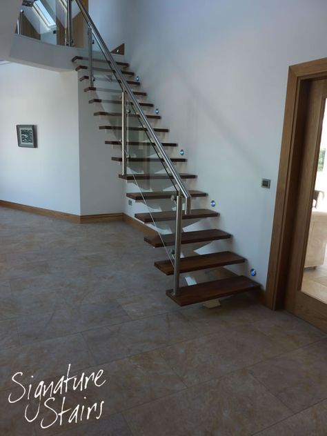 This central spine support staircase is located in the entrance hall of the home. The stairs is finished with stainless steel & toughened glass balustrade and walnut finished steps. Contemporary Staircase Design, Wood Railings For Stairs, Diy Stairs Makeover, درج السلم, Stair Makeover, Staircase Design Modern, Staircase Railing Design, Sitting Room Design, Stairs Architecture