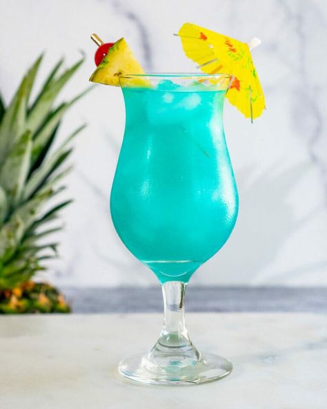 THE Blue Hawaii Drink – A Couple Cooks Hawaii Drinks, Blue Hawaii Drink, Blue Alcoholic Drinks, Blue Hawaiian Drink, Curacao Drink, Blue Curacao Drinks, Homemade Sour Mix, Christmas Pinata, Blue Hawaii Cocktail