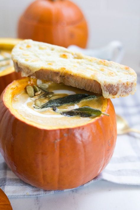 Creamy Pumpkin Soup, served in a pumpkin, is a spicy, creamy and delicious homemade pumpkin soup topped with fried sage, pepitas and cheesy toast for dipping. This will be your new favorite fall soup recipe! Fried Sage, Creamy Pumpkin Soup, Pumpkin Bowls, Fall Soup Recipes, Roasted Pumpkin Seeds, Roasted Pumpkin, Cheesy Bread, Fall Soups, Roast Pumpkin