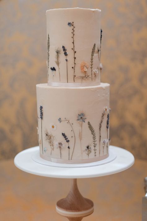 Edible pressed flower 2 tier buttercream wedding cake decorated with garden scene tyoe flowers in shades of blue, white and yellow | Hedsor House London UK 2 Tier Buttercream Cake, Wedding Cake Buttercream Flowers, Pressed Flower Cake, 2 Tier Wedding Cakes, Hedsor House, Edible Flowers Cake, White Buttercream, London Cake, Floral Wedding Cake