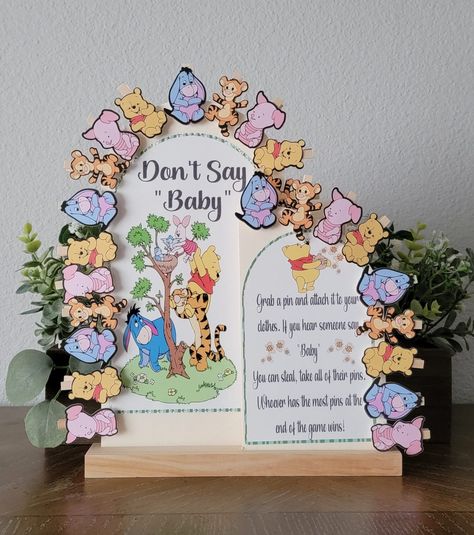 "Don't Say Baby" Winnie the Pooh & Friends mini clothe pins holder. (Characters are sold separately). You may also use plain mini cloth pins without the Character's. * Wood boards with stand * Fits up to 24 Mini clothe pins with the Characters. 30 mix Characters with plain cloth pins and 60 plain mini cloth pins. * Can be personalized upon request by messaging * Measurements: 10x15x12.2in * Print is black ink Note: The wording in the board will be as seen on the picture. Unless personalization h Baby Pooh Baby Shower Ideas, Vintage Winnie The Pooh Gender Reveal Ideas, Winnie The Pooh Gender Reveal Party, Winnie The Pooh Nursery Theme, Winnie The Pooh Baby Gender Reveal, Winnie The Pooh Baby Shower Table Decor, 100 Acre Woods Baby Shower Ideas, Winnie The Pooh Shower Ideas, Winnie The Pooh Gender Reveal Ideas