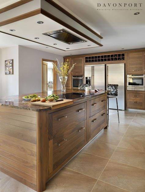 The kitchen island in this design is used as a practical cooking area. With an… Kitchen Island Hob, Kitchen Island Range Hood, Kitchen Island Range, Kitchen Diners, Kitchen Island With Stove, Walnut Island, Top Kitchen Designs, Transitional Kitchen Island Lighting, Kitchen Island Lighting Modern