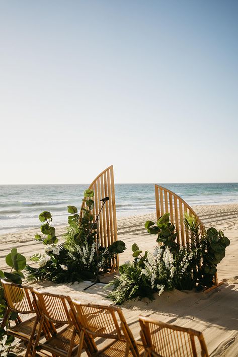 This minimalist, wooden arch paired with lush greenery and tropical florals sets the perfect scene for a beachfront ceremony at Villa Santa Cruz in Todos Santos. Ideal for couples looking for a modern, natural look that complements the ocean backdrop. The simple lines and organic design add a touch of elegance to this unique beach wedding setup. #VillaSantaCruzWedding #BeachCeremonyArch #TodosSantosWedding #MinimalistWeddingDecor #BeachfrontWeddingInspo Tropical Ceremony Decor, Earthy Beach Wedding, Tropical Backdrop Wedding, Tropical Ceremony Arch, Beach Ceremony Arch, Tropical Minimalist Wedding, Hawaiian Wedding Decor, Minimalist Tropical Wedding, Unique Beach Wedding Ideas