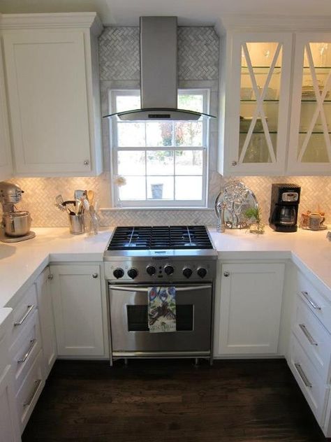 professional kitchenaid gas cooktop with convection oven. oven in front of window. stainless vent in front of window. LED vent hood with arabescato herringbone pattern backspash. white shaker cabinets. white thick slab quartz countertops. LG brand. Empire collection hardware. Kitchen Vent, Kitchen Hoods, Kitchen Stove, Trendy Kitchen, Kitchen Redo, Kitchen Window, Updated Kitchen, White Cabinets, Kitchen Layout