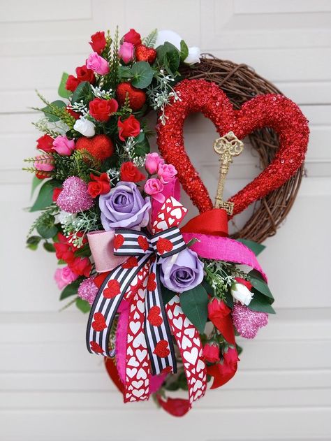 This Valentine's Day wreath is very bright and elegant! It features silk pink, red and white roses beautifully arranged with assorted greenery and baby-breath grass, accented with the large red glittered Heart ornament with the gold Key to your heart in the middle, two large silk lavender roses, glittered red and pink hearts throughout, and topped with a gorgeous multi-ribbon bow. The wired ribbons are easy to fluff year after year.  Makes a great gift! The wreath is constructed to provide years of enjoyment and would be a lovely family heirloom. READY TO SHIP  It's made on a 14-inch grapevine base and measures 20 inches in width, 25 inches in height with the bow tales hanging down from tip to tip, and 7 inches in depth.   Your wreath will arrive with a loop ready to hang. It will also arr Roses Wreath, Valentine's Day Wreath, Red And White Roses, Wedding Wreath, Love Decor, Lovely Family, Gold Key, Wreath Wedding, Wedding Wreaths