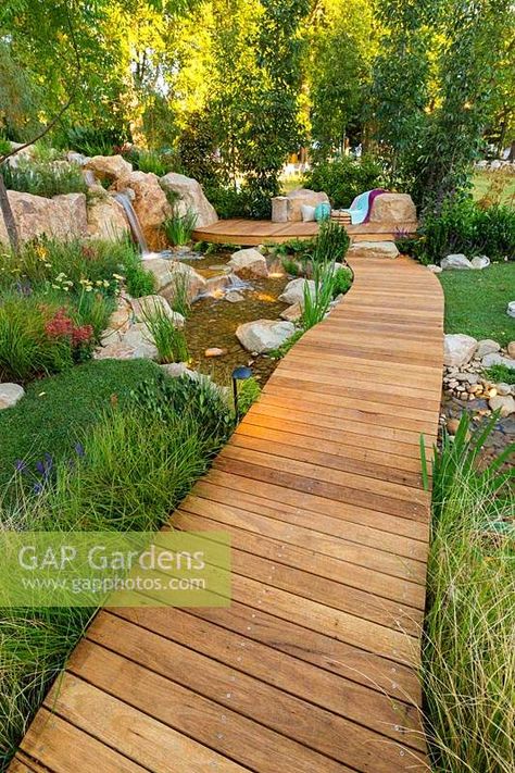 A timber boardwalk over a naturalistic stream leading to a seating area, surroundings planted out with a variety of grasses, shrubs and trees. Garden Path To Seating Area, Boardwalk Garden Path, Boardwalk Backyard, Garden Boardwalk, Backyard Boardwalk, Timber Boardwalk, Garden With Pots, Ideas For Balcony, Garden Redesign