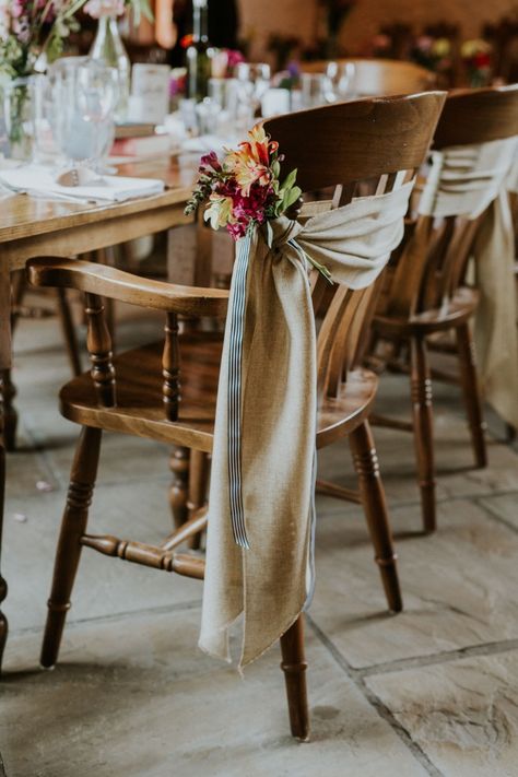 Hessian chair sash with cottage garden flowers and stripe ribbon dressed by Simply Bows and Chair Covers South Wales #hessian #chairstyling #vintage Hessian Chair Sash, Outdoor Wedding Chairs, Western Boho Decor, Chiavari Chairs Wedding, Hessian Wedding, Western Chair, Boho Outdoor Wedding, Cottage Garden Flowers, Chairs Wedding