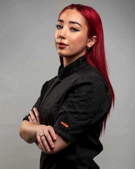 Female Pastry chef with bright red colour hair wearing a black chef jacket standing from the side with her arms crossed Chef Profile Picture, Chef Photoshoot Ideas Photo Shoot, Chef Poses Photo Ideas, Pastry Chef Photoshoot Ideas, Chef Pictures Photo Ideas, Chef Branding Photos, Chef Photoshoot Ideas Cooking, Chef Poses, Pastry Chef Photoshoot