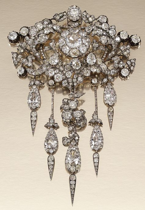 DIAMOND DEVANT DE CORSAGE, 1860S.  Of foliate design, centring on a diamond cluster within an open work surround of acanthus and ivy leaves, suspending five articulated pendant drops, set with cushion-, pear-shaped, circular- and rose-cut diamonds, further embellished with cushion-shaped and circular-cut stones in cut-down collets, later brooch fitting, original fitted case. Georgian Jewelry, Ivy Leaves, Sterling Silver Brooch, Antique Brooches, Diamond Brooch, Royal Jewels, Gemstone Jewellery, Royal Jewelry, Deco Jewelry