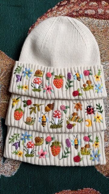 Kerri 💐🐇🐝 on Instagram: "Such a sweet set of custom dreamscape beanies. They look like a cute lil family. I’ll be working on these for the foreseeable future and I couldn’t be happier! Which part is your favorite? 🥰🌿🐌🍄🦋🍓🌙🌸🐝🌹💖" Embroidery Beanie Ideas, Embroidered Beanie Diy, Beanie Embroidery Ideas, Embroider Beanie, Wearable Embroidery, Beanie Embroidery, Embroidered Beanie, Hat Embroidery, Sewing Embroidery Designs