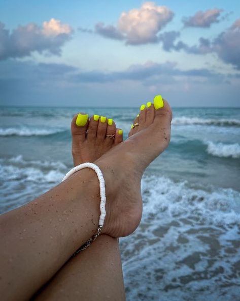 Set against a breathtaking beach vista, these vibrant neon yellow toenails exude the essence of summer excitement. This fluorescent polish is tailor-made for beach escapades, casting a luminous glow under UV light for those memorable summer soirées. Infusing a lively burst of color, it effortlessly elevates the laid-back beach ambiance and injects a whimsical charm into any ensemble. Neon Toes Toenails, Yellow Toe Nail Designs, Neon Toe Nails, Yellow Toe Nails, Heels Tumblr, Blue Toe Nails, Summer Nails Colors Designs, Diy Steps, Beach Backdrop