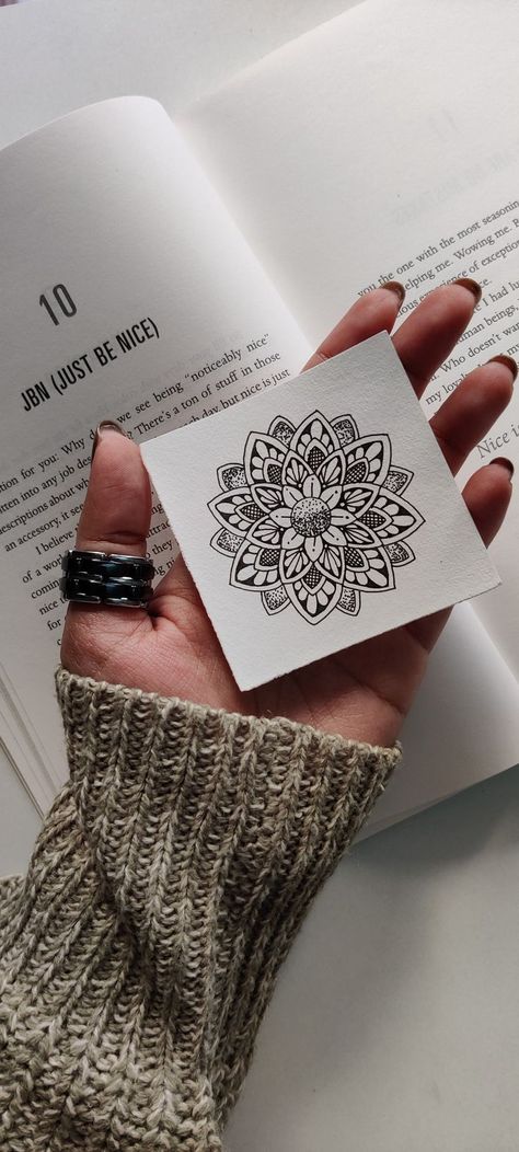 Mini Mandala Hand holding a mandala drawing over an open book with chapter titled Just Be Nice. Cozy sweater and rings visible. | Sky Rye Design How To Start Mandala Art, Mandala Drawing Aesthetic, Mini Mandala Drawing Easy, Mandala Art Small Design, Small Canvas Mandala Art, Mini Zentangle Art, Mini Mandala Art Designs, Basic Mandala Design, Mandala Small Tattoo