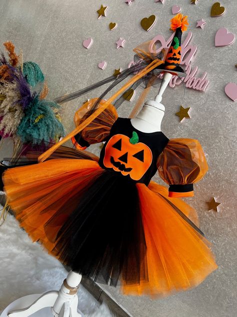 Halloween Dress This Halloween dress, the sweetest option of Halloween, will be very good for your children! This dress, which has a very fluffy skirt, a short-sleeved top, and an orange-black color suitable for the Halloween theme, is designed to make children happy. The hair accessory of the dress is included with the dress. This hair accessory completes the outfit. The hair accessory and dress combination will look great on girls. Toddler Girl Witch Costume, Puffy Birthday Dress, Costume Toddler Girl, Tulle Costume, Flower Girl Dress Baby, Halloween Costume Toddler Girl, Ghost Dresses, Birthday Costume, Halloween Party Dress