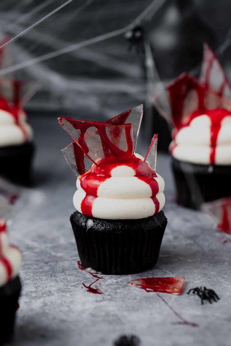 These bloody broken glass cupcakes are the perfect spooky Halloween treat!! They have a rich, black cocoa cupcake base and are filled with creamy white chocolate ganache blood. Then topped with white chocolate buttercream, edible sugar glass shards, and edible fake blood! Glass Cupcakes, Gross Halloween Foods, Brain Cupcakes, Recetas Halloween, Ghost Cupcakes, Sugar Glass, Black Cocoa, Spooky Halloween Treats, White Chocolate Buttercream