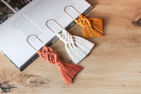 "This boho macrame paperclip bookmark will assist you by keeping page or separating sections of your journal or planner. It is perfect for those who read a lot of books as it's a functional accessory for any bookworm. Great as a planner page marker.  Made of 100% natural biodegradable cotton string attached to a 5cm x 2.3cm (roughly 2\" x 1\") gold coloured metal paperclip. Packaged in a compostable biodegradable Nativia clear film. Available in 3 styles and 3 colours. You can mix and match whichever colour and style you like if you opt in for the set of 3 bookmarks. If you have any questions or requests, please do not hesitate to get in touch! Paulina x" Paper Clip Macrame, Macrame Bookmark Paperclip, Macrame Paper Clip, Planner Page Marker, Macrame Bookmark, Macrame Crafts, Macrame Accessories, Pola Macrame, Selling Ideas