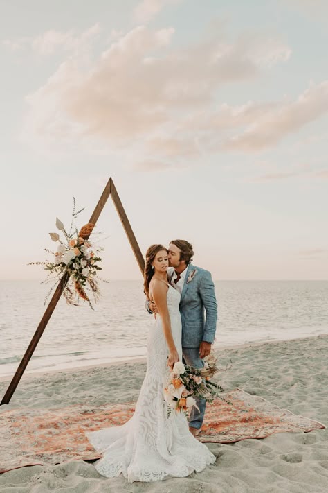 Boho beach ceremony decor with wood triangle arch, modern boho florals, and boho ceremony rug. Wood Triangle Arch, Beach Ceremony Decor, Decor With Wood, North Captiva Island, Boho Ceremony, Intimate Beach Wedding, Beach Wedding Arch, Wood Triangle, Boho Florals