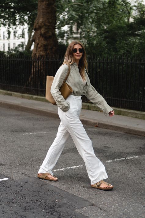 Emma Hill wears sage green linen shirt, beige ribbed vest top, white linen tailored pleated wide leg trousers, Birkenstock Gizeh big buckle sandals, Little Liffner Tulip tote bag. Chic casual Summer outfit Birkenstock Gizeh Outfit, White Birkenstock Outfit, Green Trousers Outfit, Birkenstock Outfit Summer, Green Shirt Outfits, Linen Shirt Outfit, Emma Hill, Slow Clothing, 70s Inspired Outfits