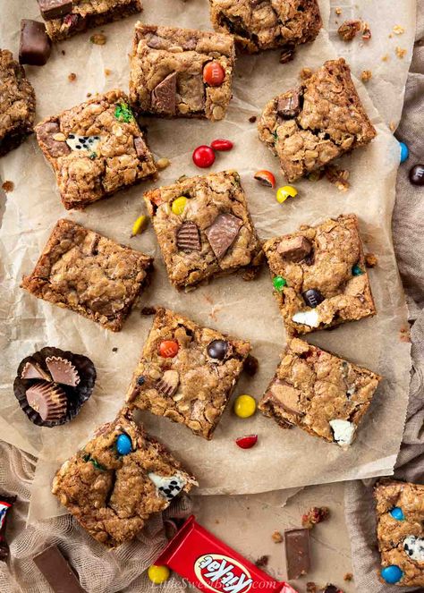 These thick and chewy cookie bars are loaded with Halloween chocolates and hearty rolled oats. They are super easy to make and an excellent way to use up any leftover Halloween candy. Snickers Cookie Bars, Leftover Candy Cookies, Halloween Candy Cookies Leftover, Candy Bar Cookie Bars, Leftover Halloween Candy Cookie Bars, Halloween Candy Cookie Bars, Leftover Halloween Candy Cookies, Candy Cookie Bars, Halloween Candy Cookies