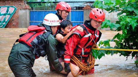 Rescue workers help an elderly woman cross a flooded street in Guilin, Guangxi province on July 3, 2017.  Floods in southern China have killed at least 15 people over the past few days and forces thousands of people to evacuate. (STR/AFP/Getty Images) Rescue Workers, Elderly Woman, Class 1 A, Guilin, Weather Channel, The Weather Channel, Historical Landmarks, July 3, China Travel