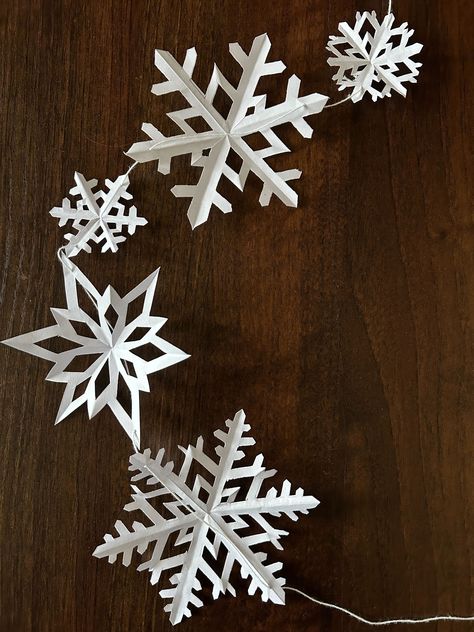 How to Make Paper Snowflake Garland for Christmas; Hanging Paper Snowflakes From Ceiling, Paper Snowflakes From Ceiling, Paper Snowflake Aesthetic, Window Snowflakes Diy, Snowflake Paper Garland, Paper Snowflake Garland Diy, Snowflake Mobile Diy, Paper Snowflakes Hanging From Ceiling, Snowflake Chain Paper