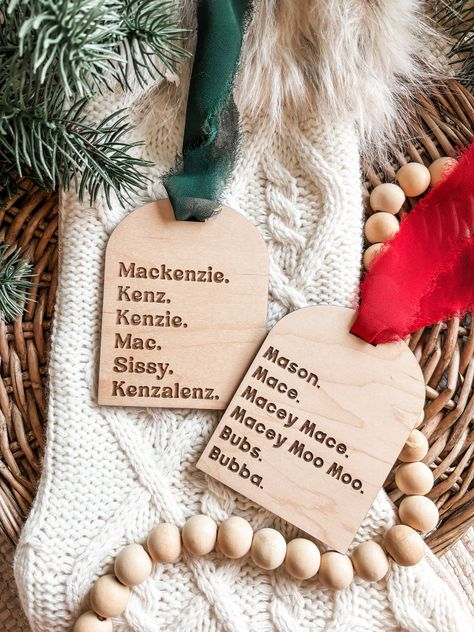 "If you have a ton of cute nicknames for your child or even your pet, this ornament is for you! DETAILS - Nicknames are laser engraved. - Made from 1/4\" maple plywood. - Measures 3.5\" x 4.5\". - Comes with your choice of green, red, white, or black chiffon ribbon. HOW TO ORDER - Choose a ribbon color from the dropdown box. - Choose your font style from the drop-down box (Mackenzie is style 1, Mason is style    2). - List your nicknames in the order you would like them to appear on the ornament Christmas Name Tags Diy, Laser Engraved Ornaments, Wood Ornament Ideas, Laser Wood Projects, Wood Burning Ornaments, Christmas Wooden Crafts, Laser Ornaments, Glowforge Aura, Boho Ornaments