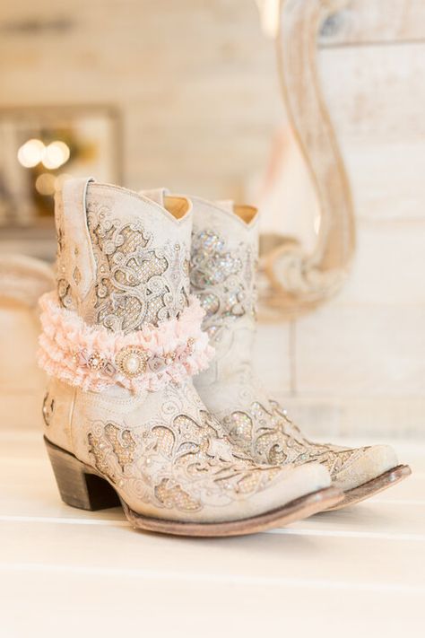 Bridal cowboy boots for barn wedding and sparkly pink lace garter Cowgirl Wedding Boots Brides, Farm Wedding Shoes Bride, White Cowboy Boots For Wedding, White Wedding Boots For Bride, Bride Boots Wedding, Bridal Boots Cowboy, Western Pink Wedding, Bridal Cowgirl Boots, Wedding Booties For Bride