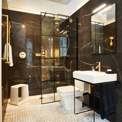 This is one of our most popular bays on display in our city centre showroom.

The Axor brushed gold brassware looks fabulous against the black tiles and Drench panelled showerscreen.

#Blackbathroom #Goldbathroom #Luxurybathroom #wetroom #Luxbathroom Black Bathroom Suite, Black Wet Room Ideas, Black And Gold Shower Bathroom, Black And Gold Bathroom Tiles, Black Shower Ensuite, Loft Bathroom Ideas Sloped Ceiling, Shower Room With Black Fittings, Black Marble And Brass Bathroom, Black Shower Screen Brass Shower