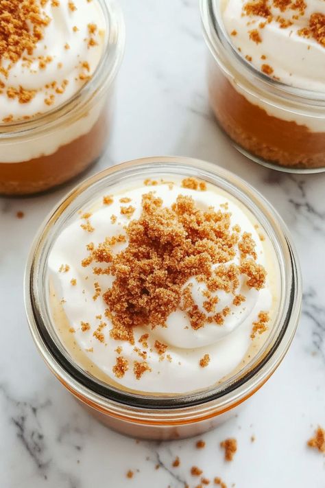 Indulge in the perfect fall treat with this easy no-bake pumpkin pie dessert in a jar recipe. Layers of creamy pumpkin filling, crispy graham cracker crumbs, and fluffy whipped cream create a delicious dessert that's not only adorable but also convenient for serving individually. These portable jars are ideal for seasonal gatherings, picnics, or simply satisfying your sweet tooth on-the-go. The rich flavors of spices and pumpkin combined with the smooth texture make these desserts irresistible t No Bake Pumpkin Pie In A Cup, Pumpkin Mason Jar Dessert, Pumpkin Pie In A Jar, Mason Jar Pumpkin Pie, No Bake Pumpkin Pie In A Jar, No Bake Pumpkin Lush Pie, No Bake Pumpkin Pie, Dessert In A Jar, Ginger Snap Cookies