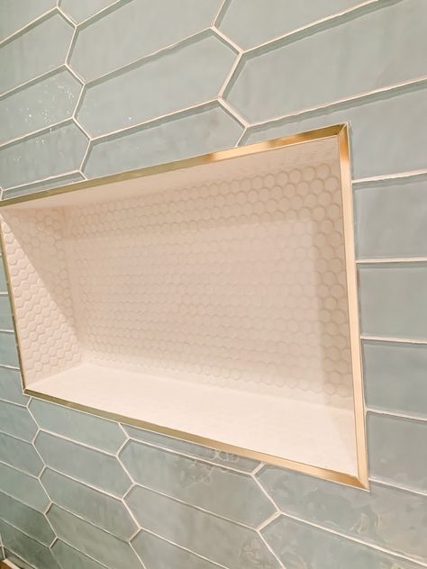 Shower niches are a great way to add storage and interest in your shower. High gloss penny tile and glass pickets accented with gold metal trim makes this pop! Shampoo Shelf In Shower, Small Office Remodel Ideas, Cottage Shower Tile Ideas, Shower Nook Ideas, Modern Master Bathrooms 2024 Trends, Timeless Bathrooms, Bad Inspiration, Master Bath Remodel, Shower Niche