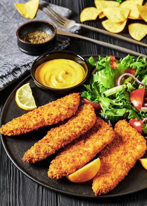 Breaded fish fillet with salad on black plate royalty free stock photo Breaded Fish Fillet, Restaurant Salmon, Salmon Fried, Breaded Fish, Fish Fillet, Yellow Mustard, Black Plates, Tortilla Chips, Fresh Food