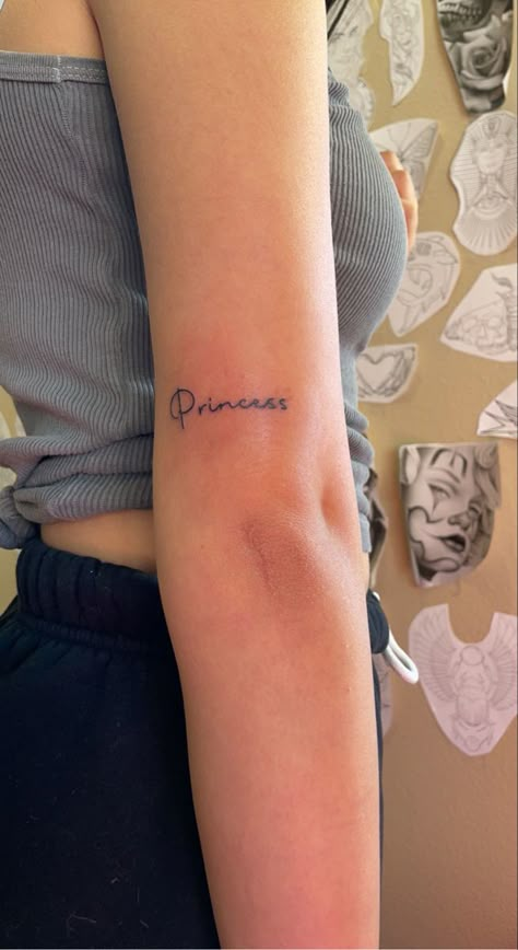 princess tattoo Princess In Arabic Tattoo, Princess Writing Tattoo, Princesa Tattoo Word, Princess Neck Tattoo, Princess Tattoo Ideas Words, Princess Aesthetic Tattoo, Barbie Tatoos Ideas, Princess Tattoos For Women, Princess Word Tattoo