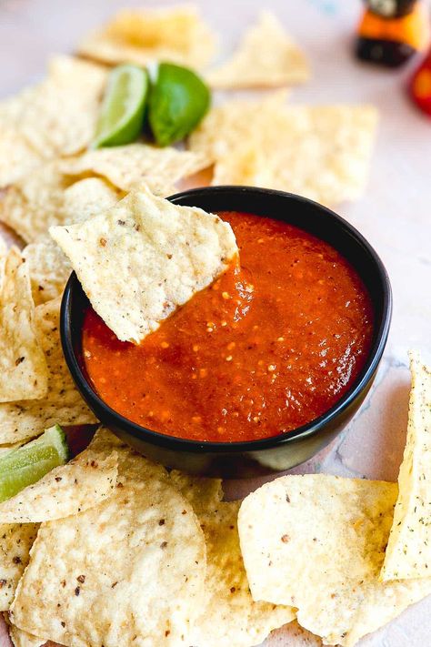 Red tomatillo salsa with a chip in the bowl. Red Tomatillo Salsa, Tomatillo Red Chili Salsa, Red Chili Salsa, Chile Salsa Recipe, Red Chile Salsa, Spicy Red Sauce, Chile Salsa, Vegan Appetizer Recipes, Roasted Tomatillo Salsa