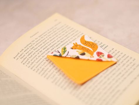 Want to spice up your reading routine with a touch of flair? Why not jazz it up with a DIY fabric corner bookmark! Say goodbye to dog-eared pages and hello to a stylish and practical accessory for your favorite reads. In this article, we'll walk you through creating your own unique corner bookmark using fabric scraps and a dash of creativity. Whether you're a seasoned sewing pro or just starting out, this project is a perfect way to unleash your imagination and personalize your reading experienc Cloth Corner Bookmarks, Corner Bookmark Sewing Pattern, Page Corner Bookmarks, Corner Bookmark Template, Corner Bookmarks Diy, Using Fabric Scraps, Reading Routine, Corner Bookmark, Sewing School