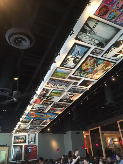 A cool ceiling at Red Robin that displays photos and paintings as if they were hung on a wall Event Ceiling Design, Interactive Ceiling, Interactive Exhibition Design, Event Entrance, Corporate Event Design, Museum Exhibition Design, Art Gallery Interior, Design Window, Interactive Walls