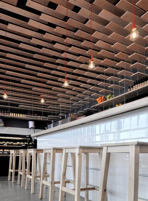 Situated in front of one of the busiest shopping malls in Madrid metropolitan area, this L-shaped store holds 3 different stalls under one wooden roof canopy, which is the most visually striking element that can be seen from the street, covering the entrance area. Architecture Ceiling, Interior Ceiling, Ceiling Detail, Ceiling Treatments, Retail Design Blog, False Ceiling Design, Restaurant Interior Design, Wood Ceilings, The Ceiling