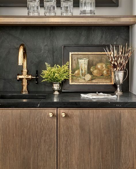 Such a great wet bar with reeded cabinet front! We love the soapstone backsplash and vintage art, as well! | Grand Traditions Homes Bar Layout, Wet Bar Designs, Home Wet Bar, Black Kitchen Cabinets, Home Luxury, White Marble Countertops, Contemporary Kitchen Design, White Cabinetry, Kitchen Cabinetry