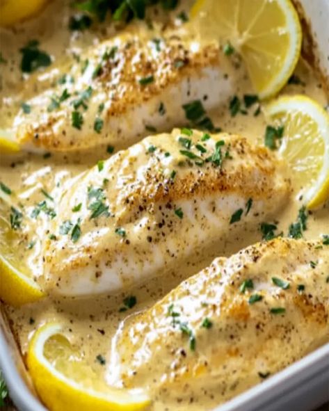 Try this delicious Baked Fish with Lemon Cream Sauce recipe! Made in one dish, it's quick, easy, and perfect for a healthy dinner. Creamy Lemon Fish Recipes, Fish Recipes With Cream Sauce, Baked Cod With Cream Sauce, Fish With Lemon Cream Sauce, Oven Cooked Fish Recipes, Lemon Picatta Fish, Tilapia With Lemon Cream Sauce, Cod In Cream Sauce Recipes, Lemon Seafood Sauce