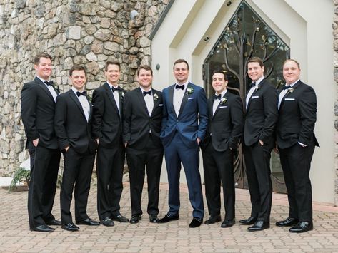 The groom designed his midnight navy tux, selecting everything from the fabric to the buttons. The wedding date was monogrammed on the back of his collar, and the couple’s crest was added to the lining. He added velvet shoes and fleur-de-lis socks in honor of his hometown of Louisville, Kentucky. The groomsmen wore their own traditional black tuxes. Navy Blue Tuxedo Wedding, Midnight Blue Tuxedo Wedding, Navy Tuxedo Wedding, Groomsmen Attire Navy, Tuxedo Ideas, Black Groomsmen Suits, Tuxedo Wedding Groomsmen, Bridesmaid Dresses Navy, Navy Blue Tuxedo