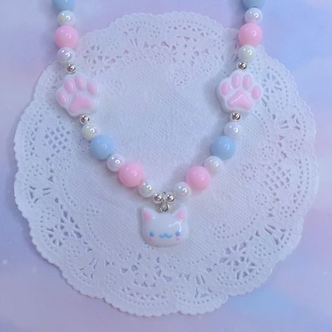 Introducing our delightful "Kawaii Kitty Dreams" Necklace - a whimsical and enchanting accessory that perfectly captures the essence of cuteness and charm. This exquisite necklace is meticulously crafted to bring a touch of magic and joy to your everyday style. Adorned with a delicate arrangement of pastel pink, serene blue, and pristine white beads, the "Kawaii Kitty Dreams" Necklace is a visual symphony of soothing colors. Nestled among these enchanting beads are two dainty stars, reminiscent Dainty Stars, Joyful Expression, Kawaii Kitty, Aesthetic Accessories, Whimsical Accessories, Pastel Beads, Kawaii Jewelry, Cat Pendant, Kawaii Accessories